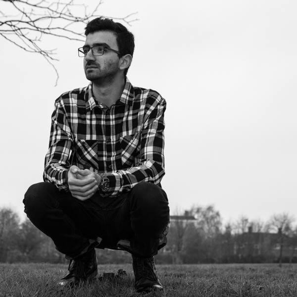 Black and white photo of Producer's Toolbox composer Dan Villalobos sitting in a plaid shirt.