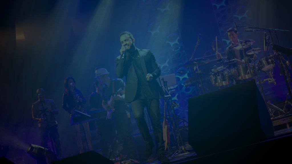 Still of a singer on stage with his band singing into a microphone in the PBS Fall Arts Festival. Flavorlab Score provided original custom music for the promo.||