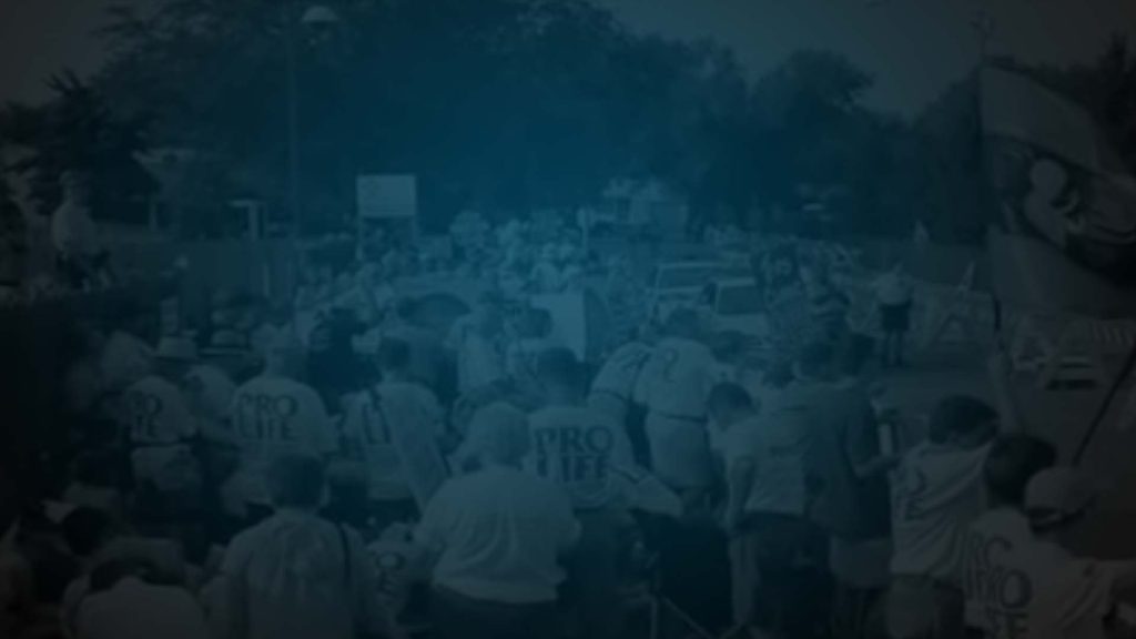 Still of crowd marching in documentary The Assassination of Doctor Tiller. Flavorlab Score provided original score for the film.|