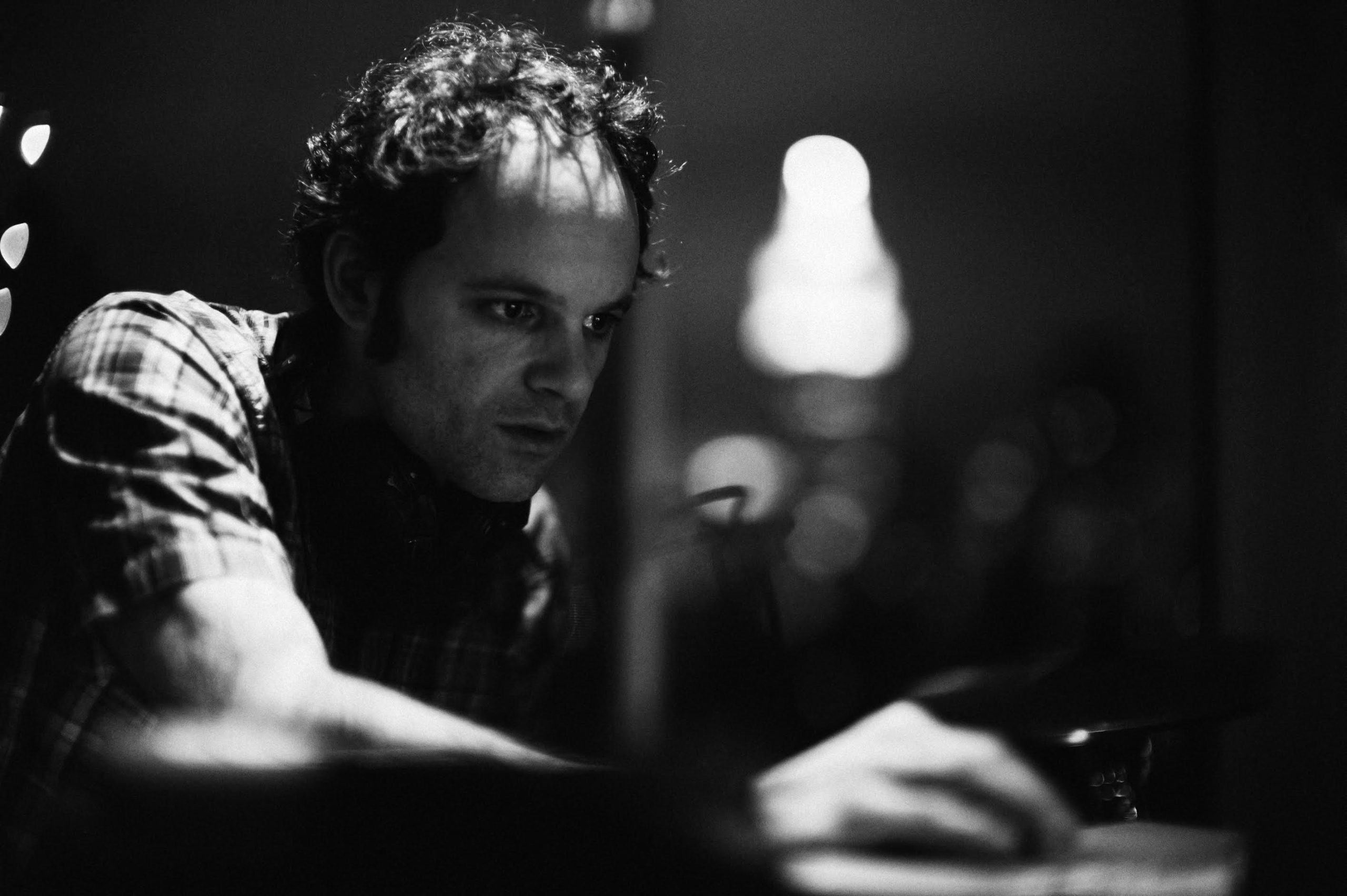 Black and white shot of Producer's Toolbox composer, Jarrod Pedone, playing drums.